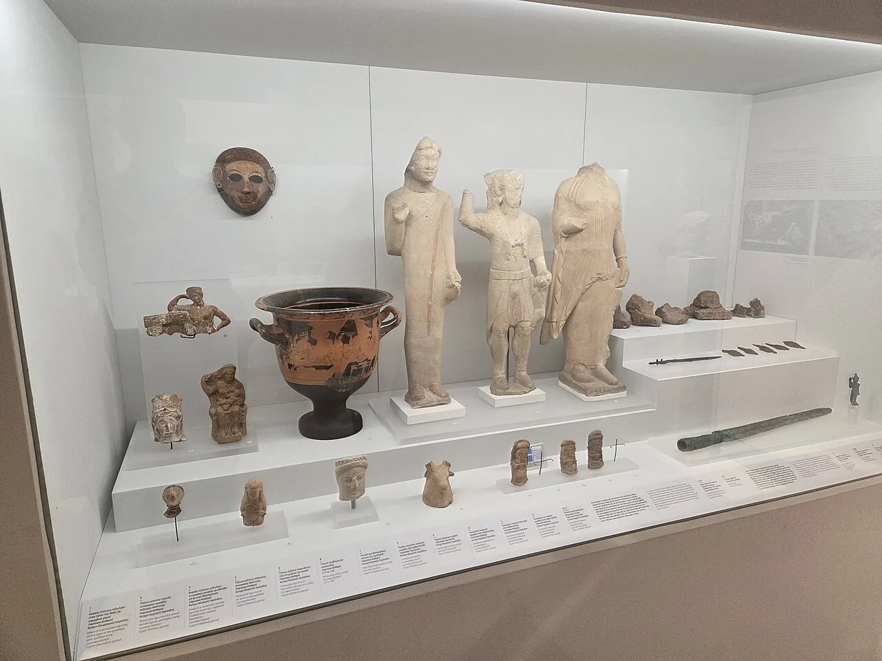 Statues and pottery in a display case at Larnaca District Museum.